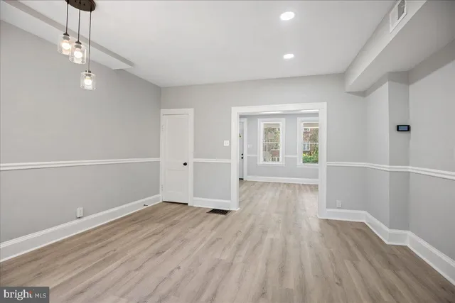 a view of empty room with wooden floor