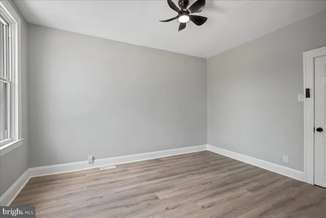 a view of a room with wooden floor and fan