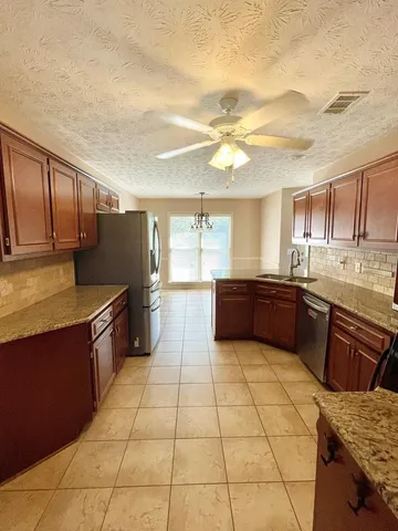a kitchen with stainless steel appliances granite countertop a refrigerator and a stove