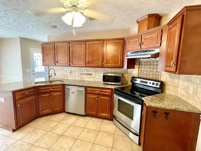 a kitchen with stainless steel appliances granite countertop a refrigerator a sink and dishwasher