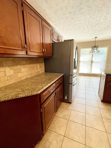 an empty room with wooden floor fireplace and a ceiling fan