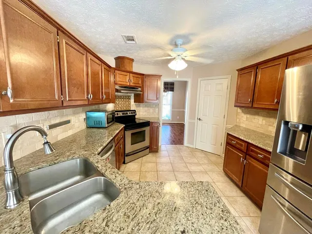 a bathroom with a sink a toilet and shower curtain