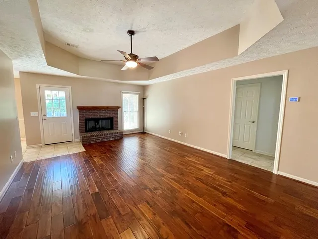 a view of a room with wooden floor and small window