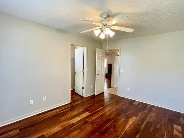 a view of a livingroom with wooden floor and a kitchen space