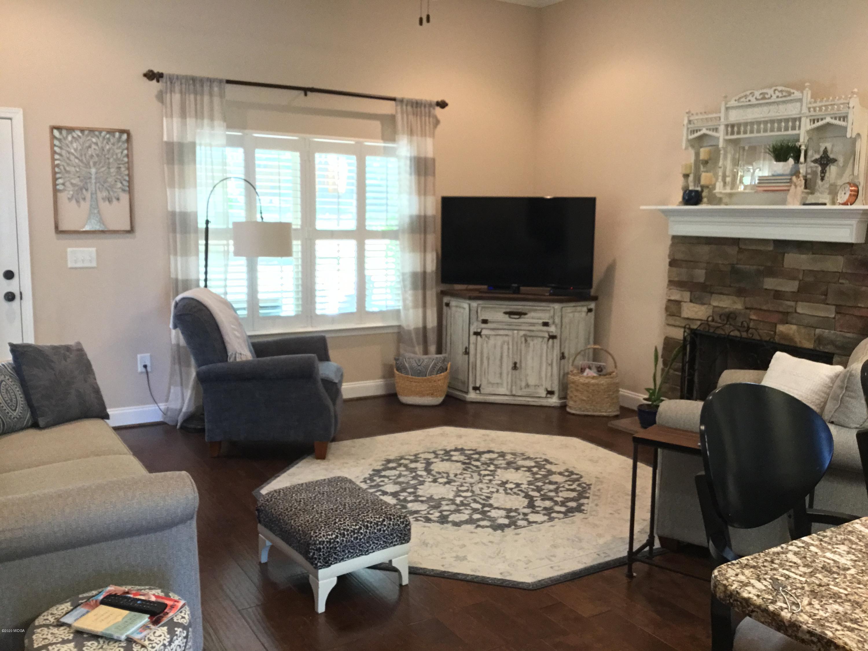 324 Walnut Grove Road Gray, GA 31032 - Photo 12 of 37 a living room with furniture a flat screen tv and a fireplace