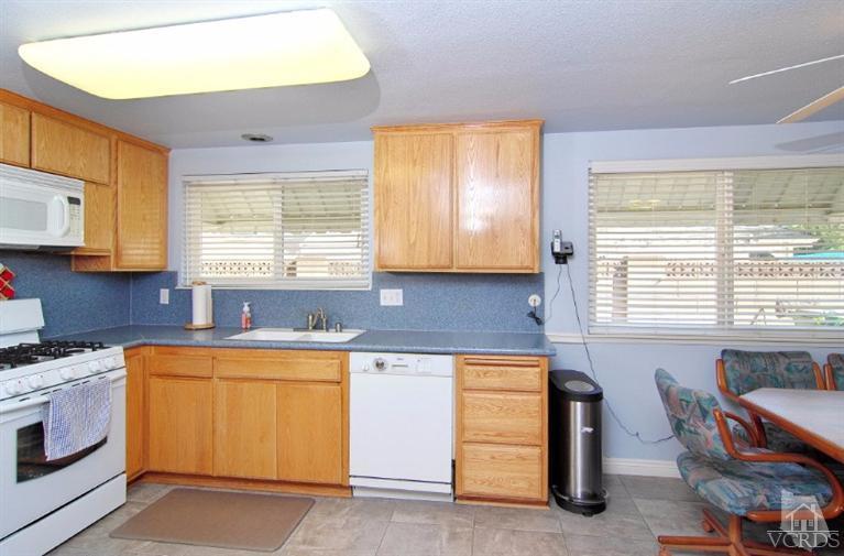 256 Kanan Road Oak Park, CA 91377 - Photo 11 of 26 a kitchen with a sink cabinets and window