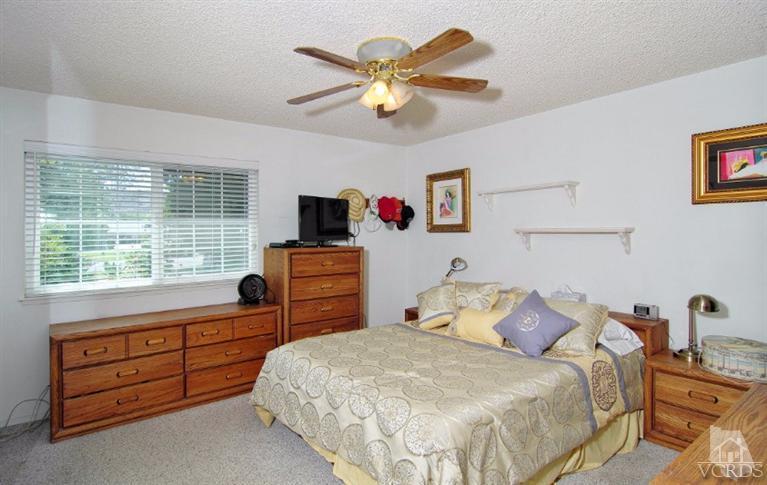 256 Kanan Road Oak Park, CA 91377 - Photo 14 of 26 a bedroom with a bed and a chandelier