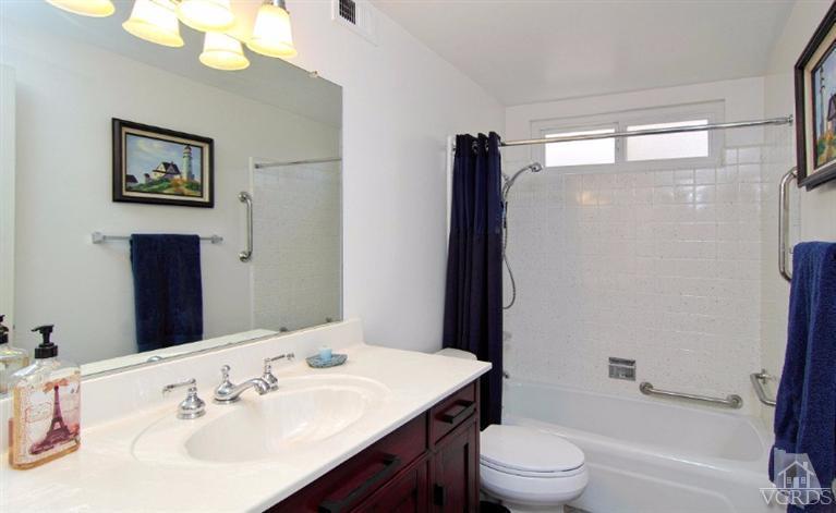 256 Kanan Road Oak Park, CA 91377 - Photo 15 of 26 a bathroom with a sink a toilet a mirror and shower