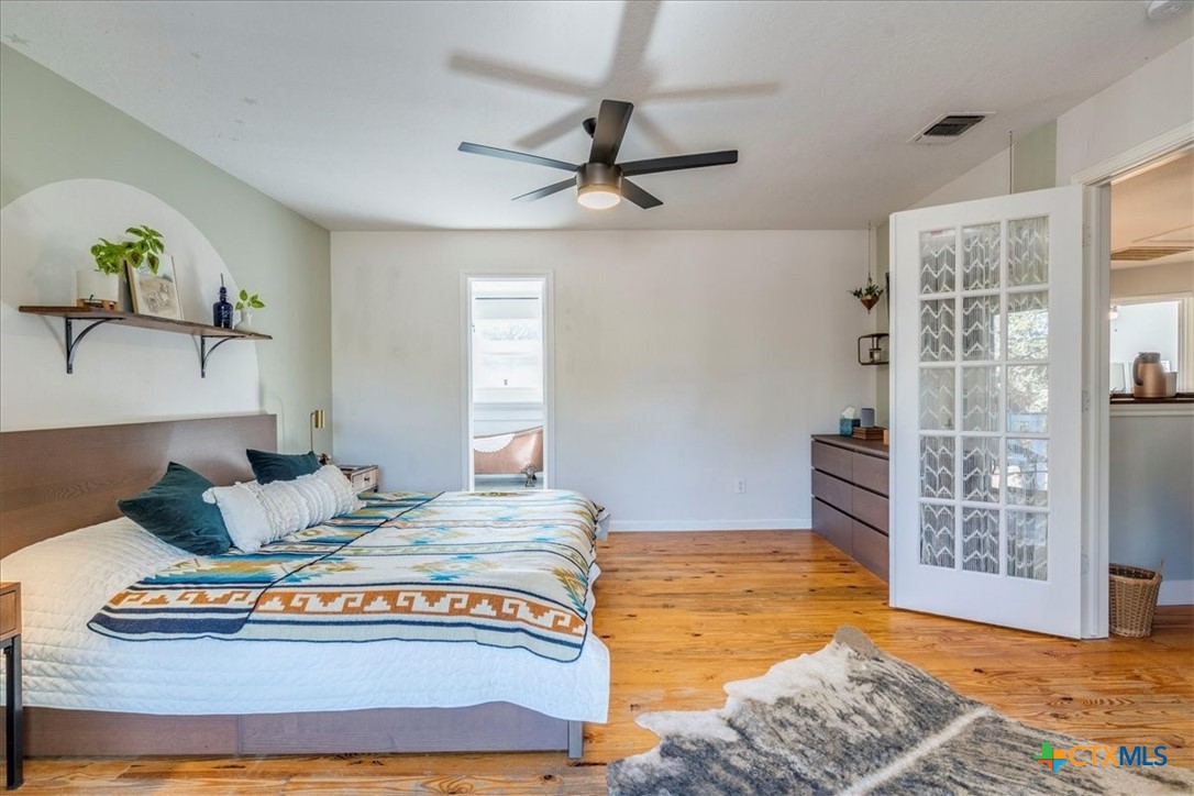 171 Pin Oak Crossing Elgin, TX 78621 - Photo 19 of 38 a bedroom with a bed and wooden floor