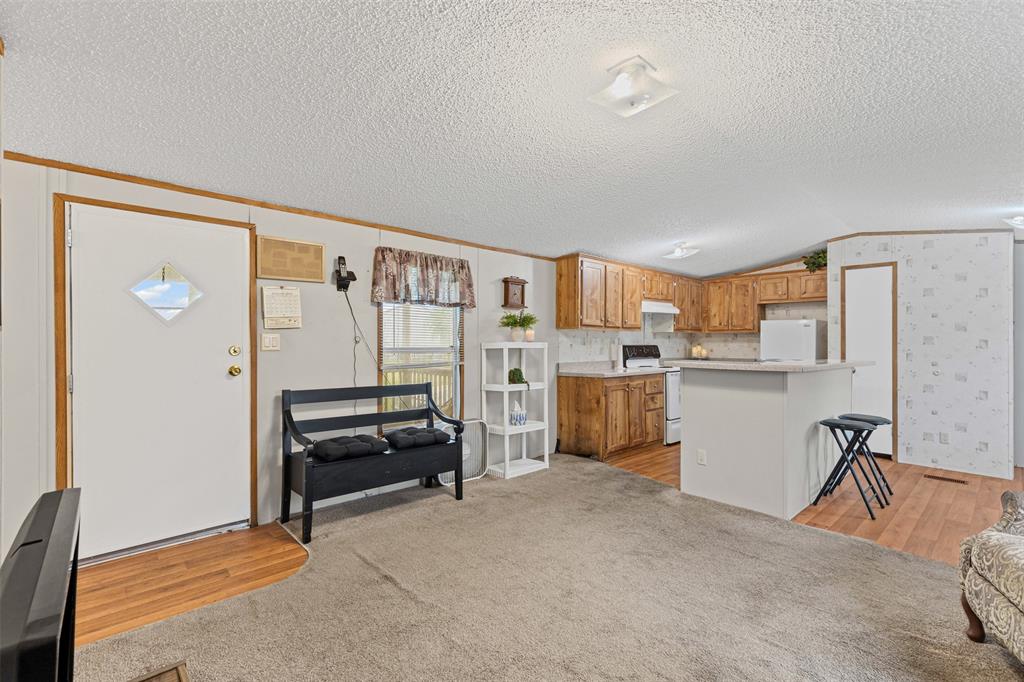 167 Hcr 4105 Covington, TX 76636 - Photo 17 of 32 Kitchen with electric stove, fridge, vaulted ceiling, light countertops, and light wood-style floors