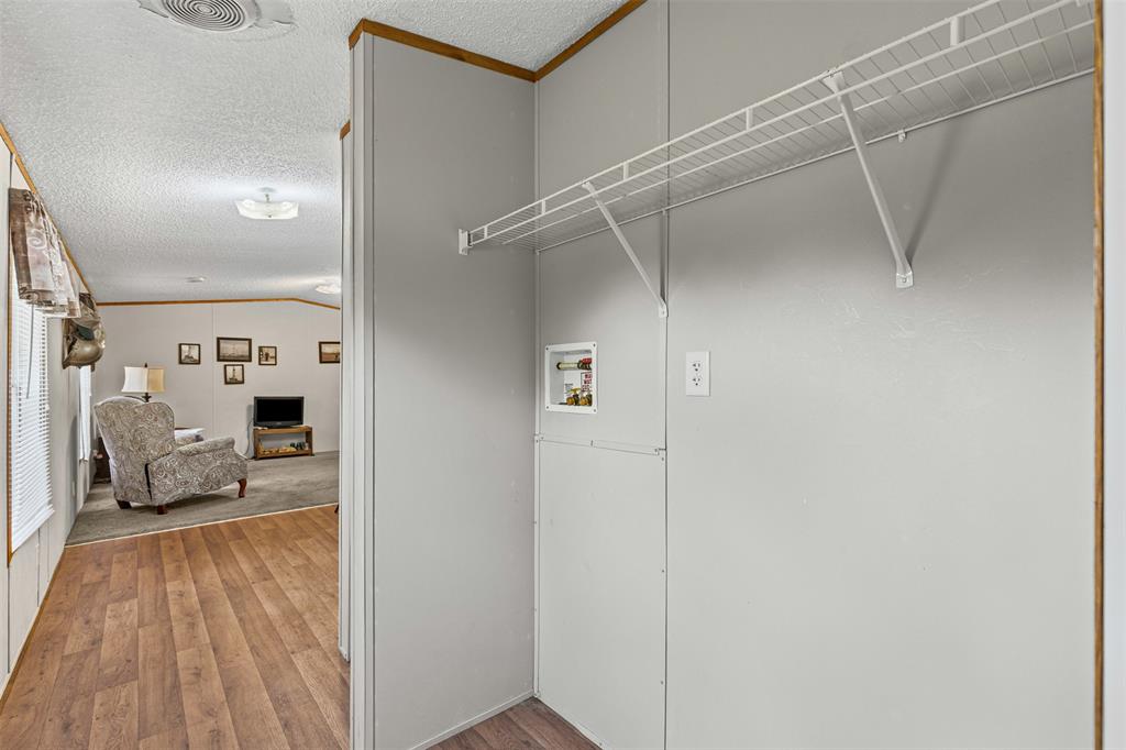167 Hcr 4105 Covington, TX 76636 - Photo 23 of 32 Laundry room with hookup for a washing machine, light wood-style flooring, and a textured ceiling