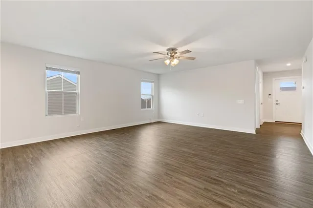 an empty room with wooden floor and window