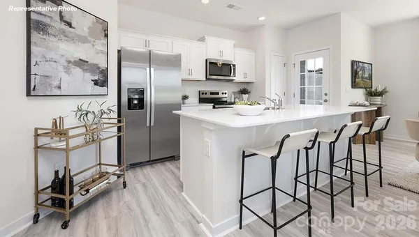 a kitchen with kitchen island a refrigerator and a stove top oven