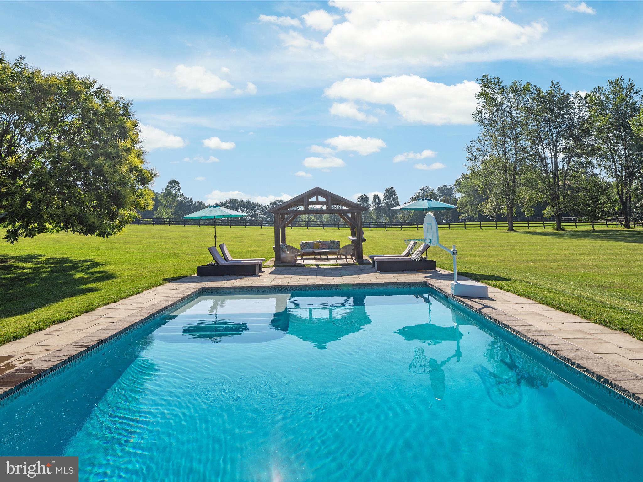 a view of swimming pool with a garden and lake view