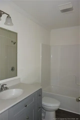 a bathroom with a granite countertop sink a toilet and shower