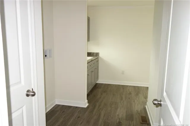 a view of an empty room with wooden floor and closet