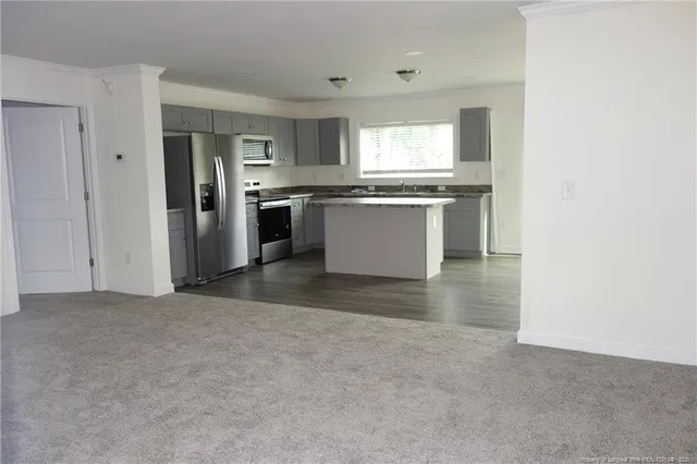 a view of kitchen with refrigerator stove microwave and cabinets