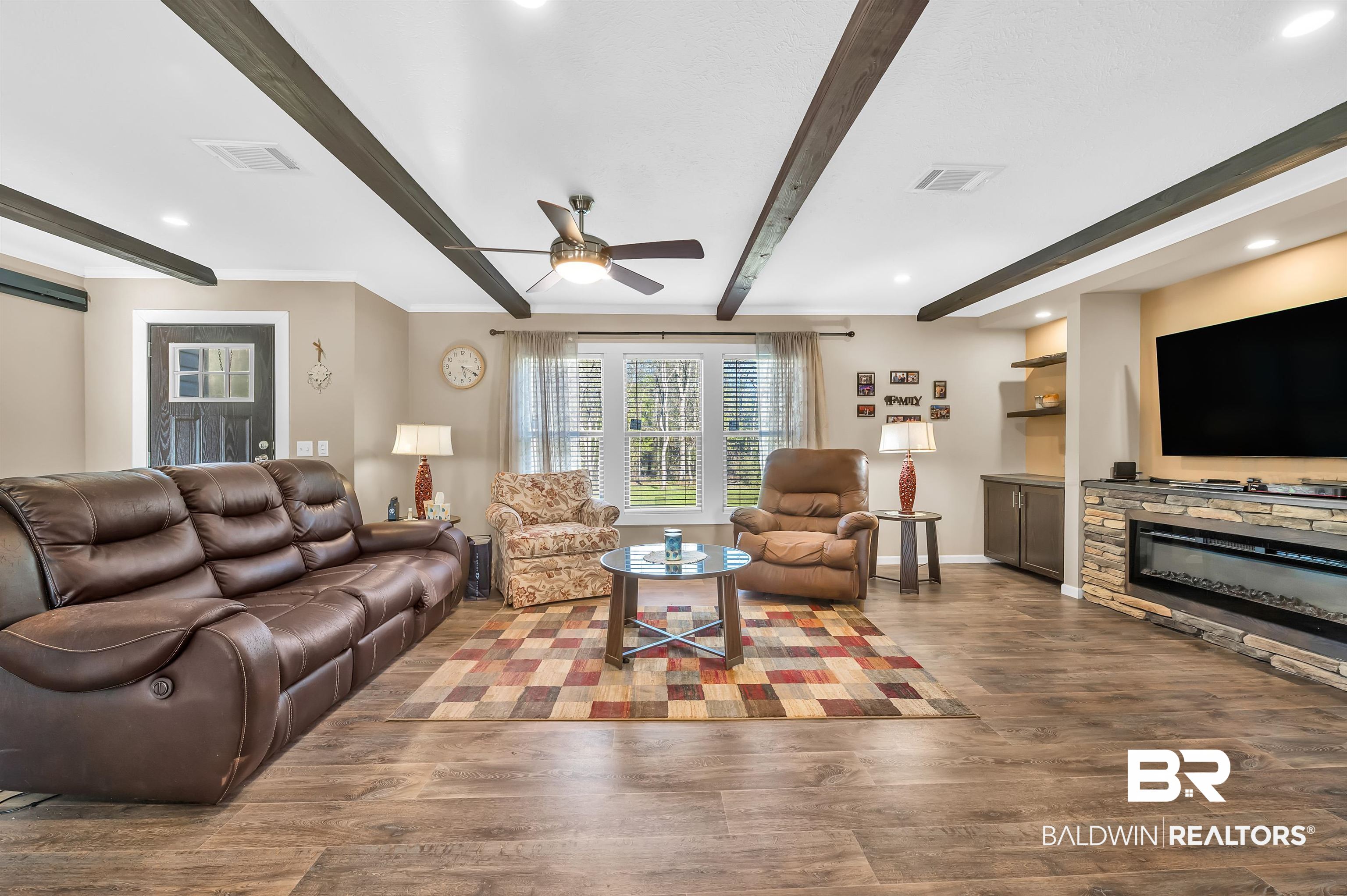 23233 Forland Road Silverhill, AL 36576 - Photo 10 of 33 Living area with visible vents, beamed ceiling, baseboards, ceiling fan, and wood finished floors
