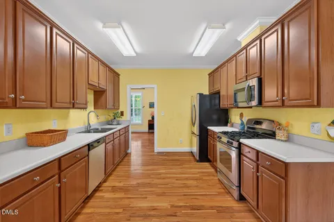 a kitchen with stainless steel appliances granite countertop wooden cabinets a sink a stove and a refrigerator