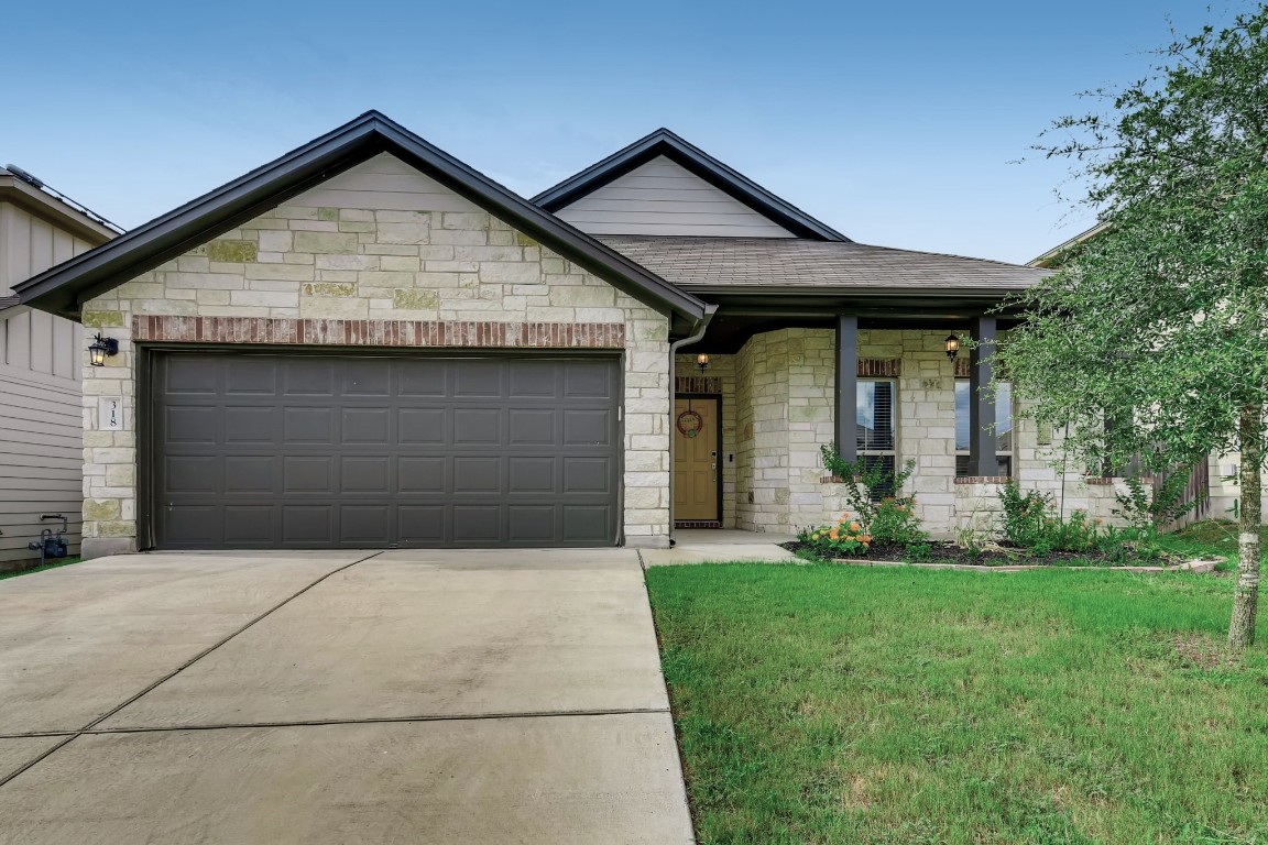 a front view of a house with a yard and garage