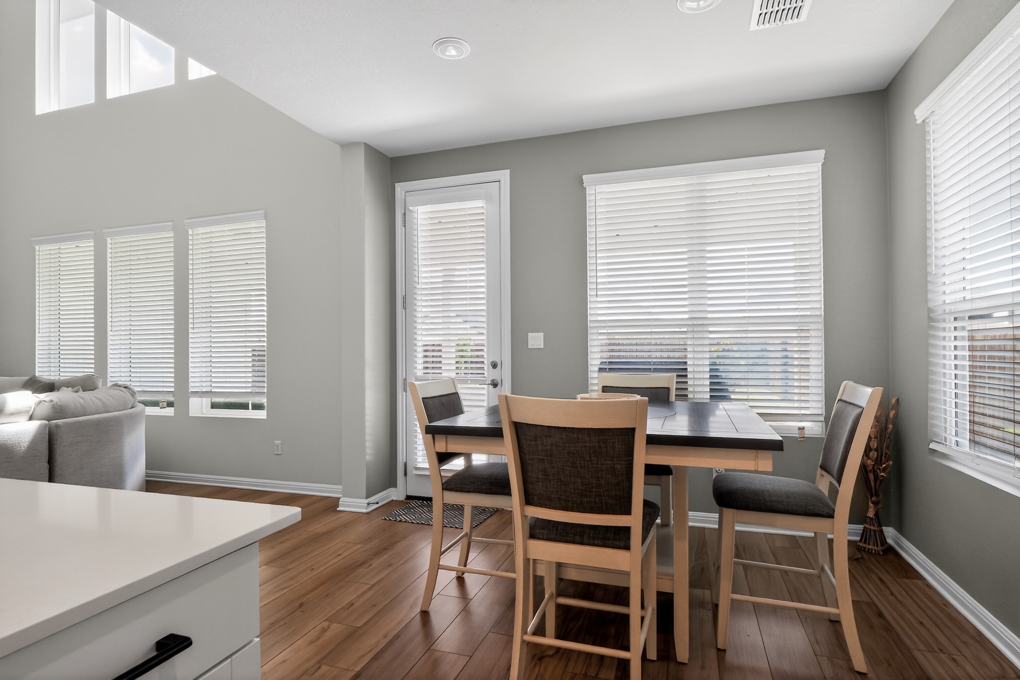 114 Bosco Road Hutto, TX 78634 - Photo 11 of 39 Bright hardwood floors flow through this welcoming dining area, complemented by tall windows and a glass-paneled door.