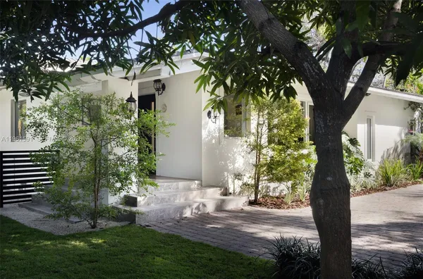 a view of a yard in front of a house with large tree