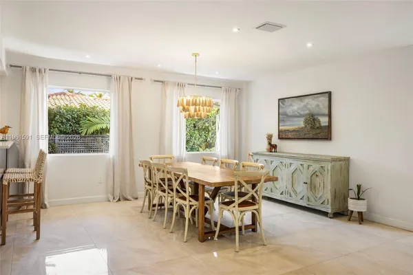 a dining area with stainless steel appliances a table and chairs