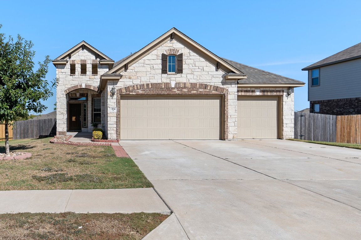 a front view of a house with a yard and garage