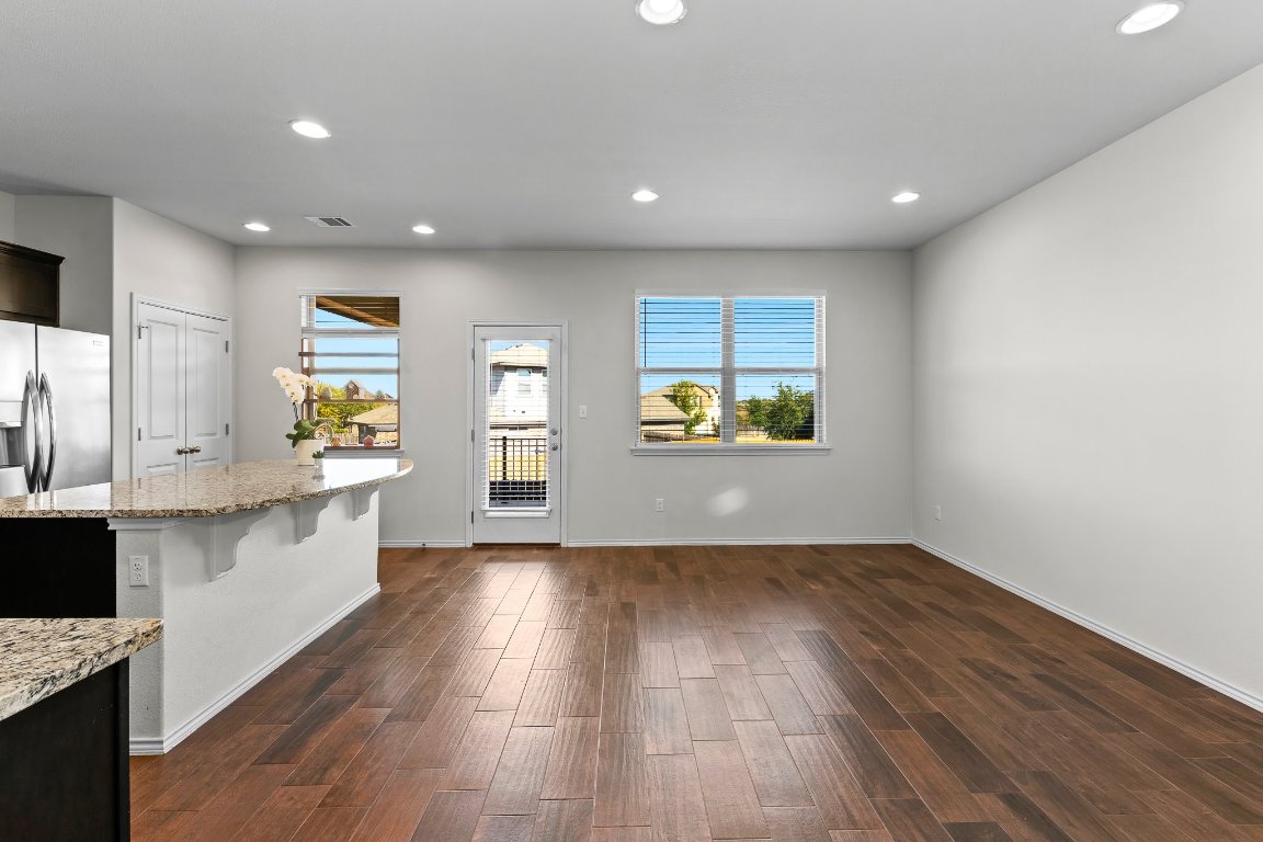 704 Coltrane Drive Pflugerville, TX 78660 - Photo 12 of 39 a view of kitchen with wooden floor electronic appliances and window