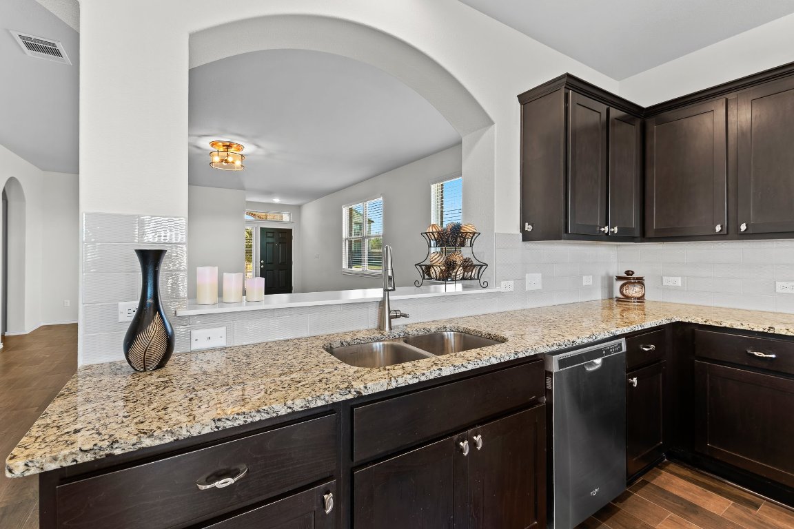 704 Coltrane Drive Pflugerville, TX 78660 - Photo 17 of 39 a kitchen with granite countertop a sink and cabinets