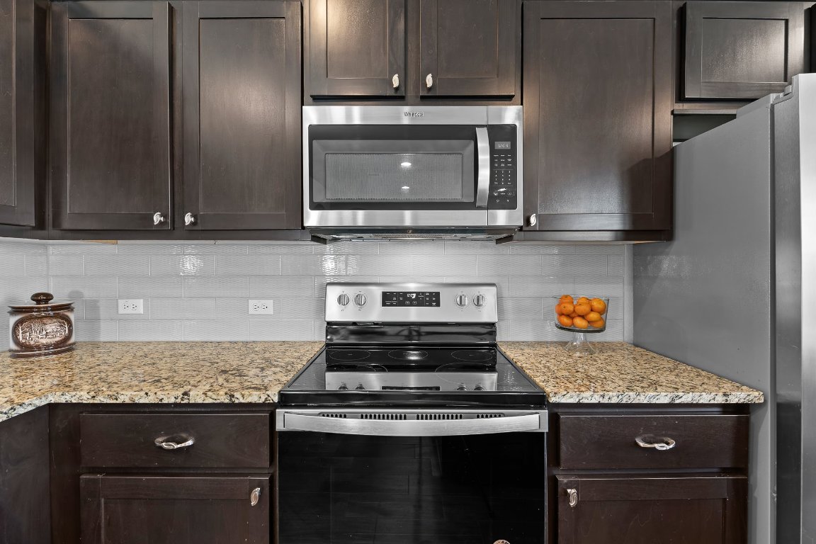 704 Coltrane Drive Pflugerville, TX 78660 - Photo 18 of 39 a stove top oven sitting inside of a kitchen