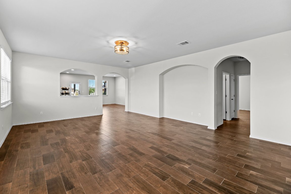 704 Coltrane Drive Pflugerville, TX 78660 - Photo 8 of 39 wooden floor in an empty room with a window