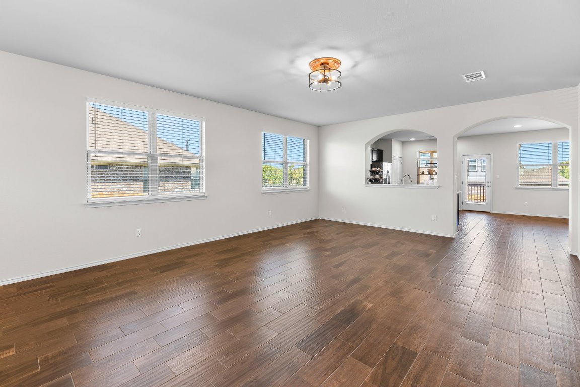 704 Coltrane Drive Pflugerville, TX 78660 - Photo 10 of 39 a view of an empty room with wooden floor and a window