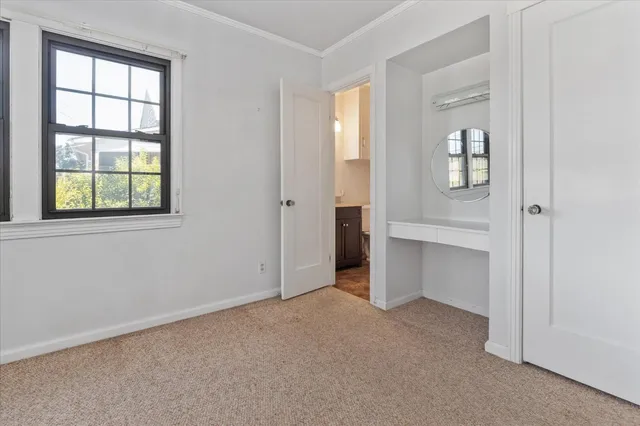 an empty room with closet and windows