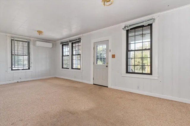 a living room with furniture potted plant and kitchen view