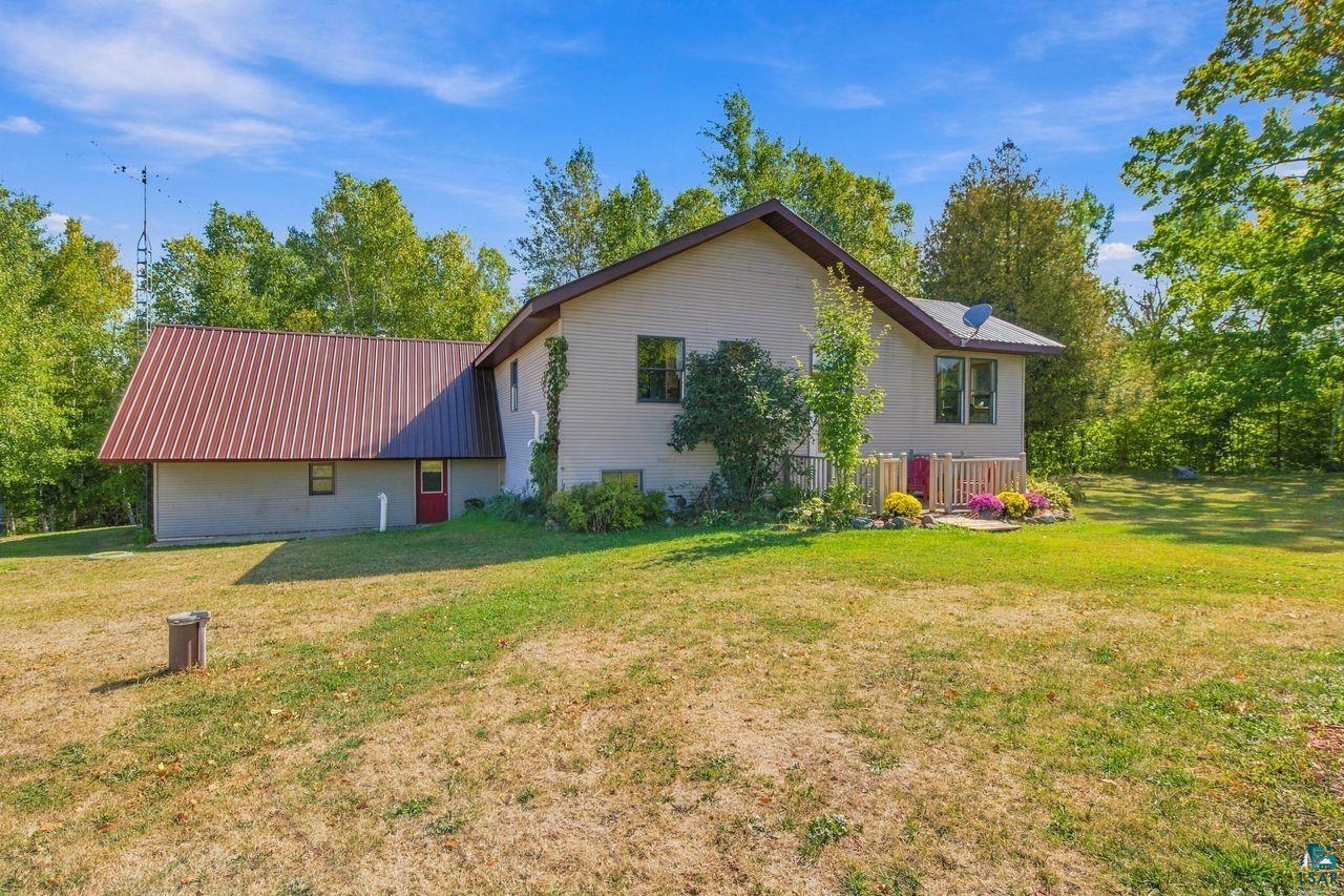 65889 Old County Road Marengo, WI 54855 - Photo 31 of 44 Property exterior featuring a metal roof, light-colored siding, and a red entry door