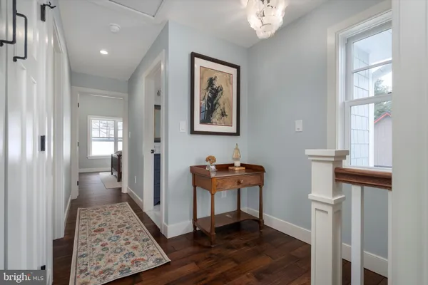 a view of a hallway to a livingroom with furniture