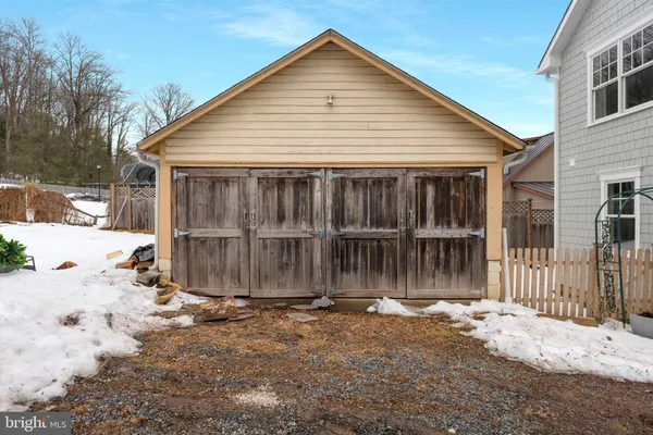 a view of a small house with wooden fence