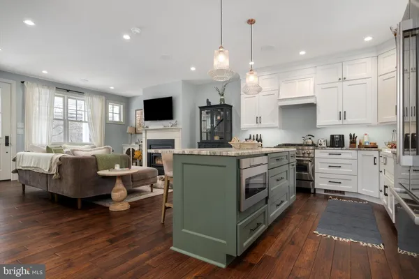 a kitchen with microwave a stove and wooden floor