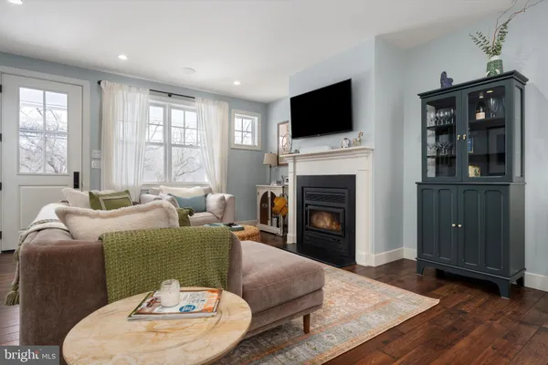 a living room with furniture a fireplace and a flat screen tv
