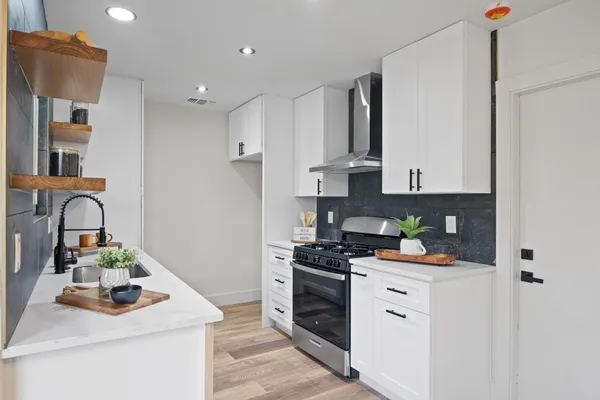 a kitchen with stainless steel appliances granite countertop a sink stove and refrigerator