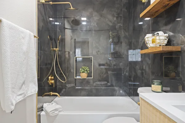 a bathroom with a sink a toilet and shower