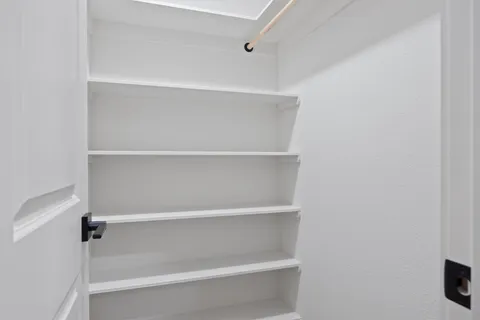 a view of walk in closet with empty racks