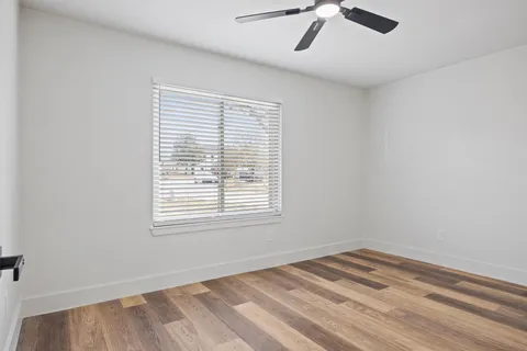 an empty room with a window and a ceiling fan