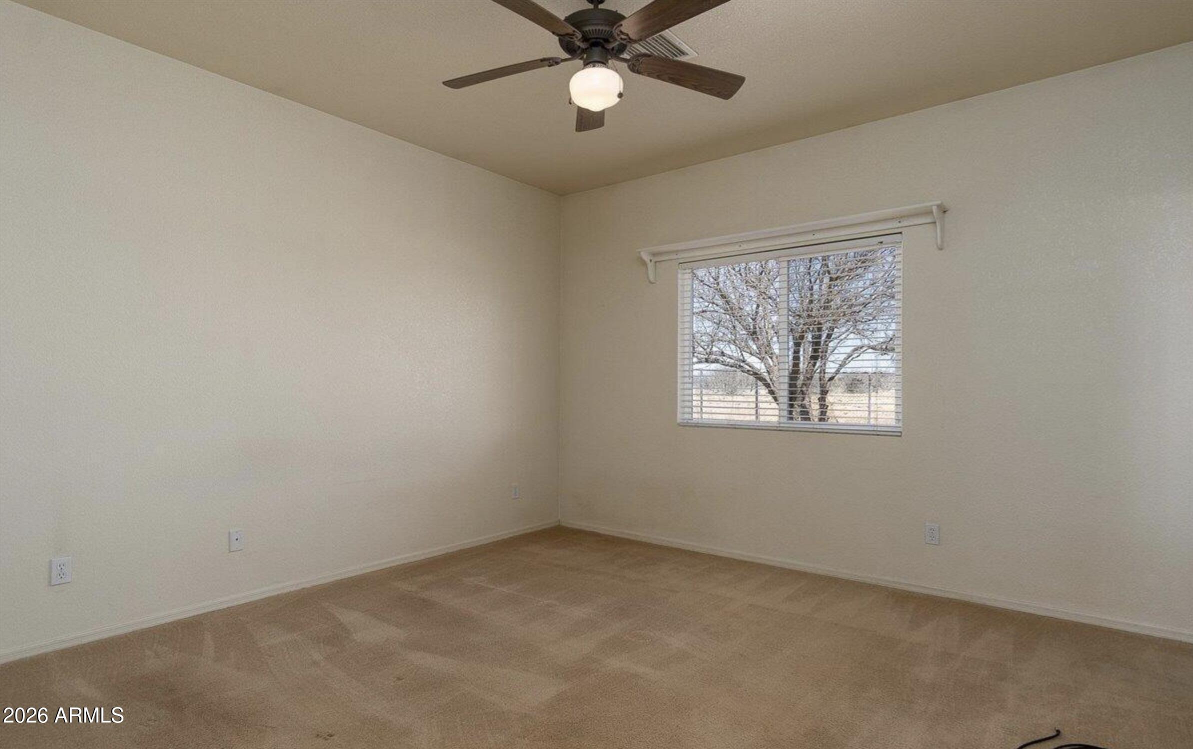 10193 East Windtalker Road Hereford, AZ 85615 - Photo 9 of 34 an empty room with a window and a fan