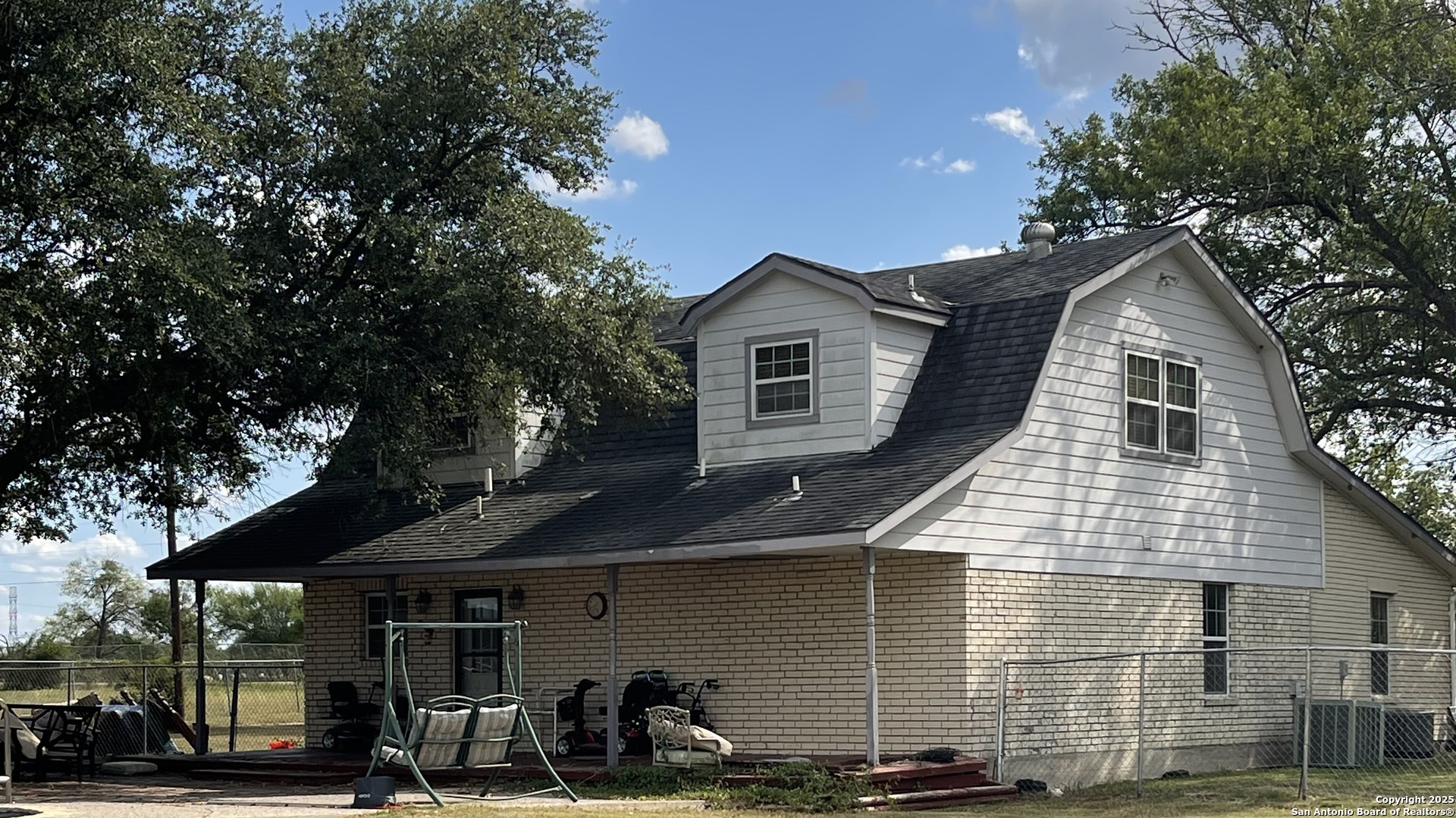 6932 Green Valley Road Cibolo, TX 78108 - Photo 4 of 18 a view of a white house with large windows and a small yard