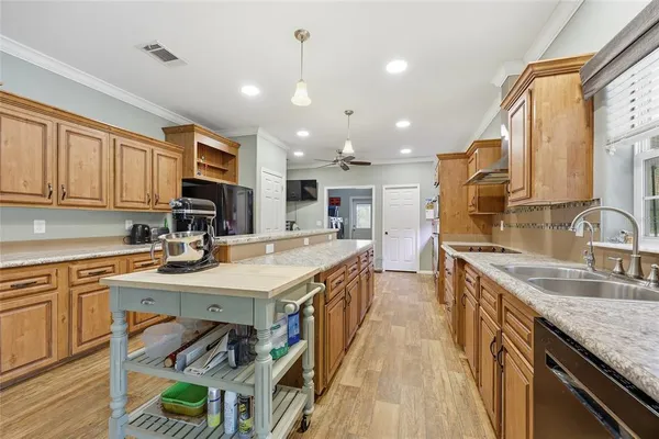 a kitchen with kitchen island granite countertop a sink stove and cabinets