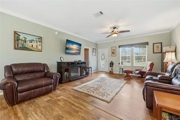 a living room with furniture ceiling fan and a window