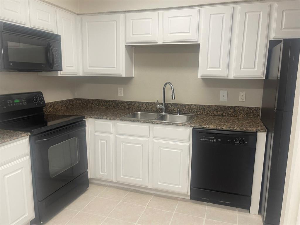 a kitchen with granite countertop white cabinets and stainless steel appliances