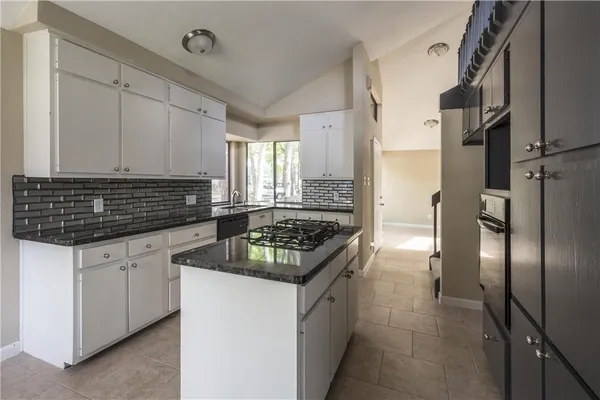 a kitchen with granite countertop a sink stove and refrigerator